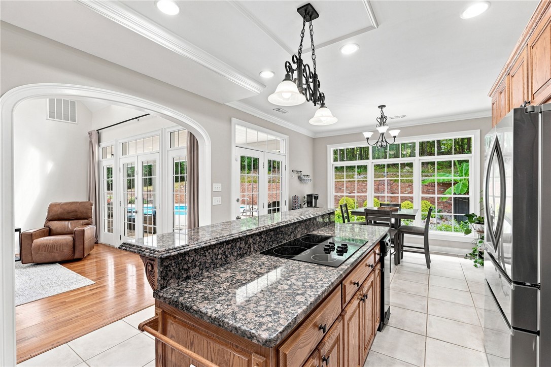 320 Watson Road Easley, SC 29642 - Photo 14 of 50 Gleaming granite countertops and classic wood cabinetry anchor this spacious, tile-floored kitchen setup.