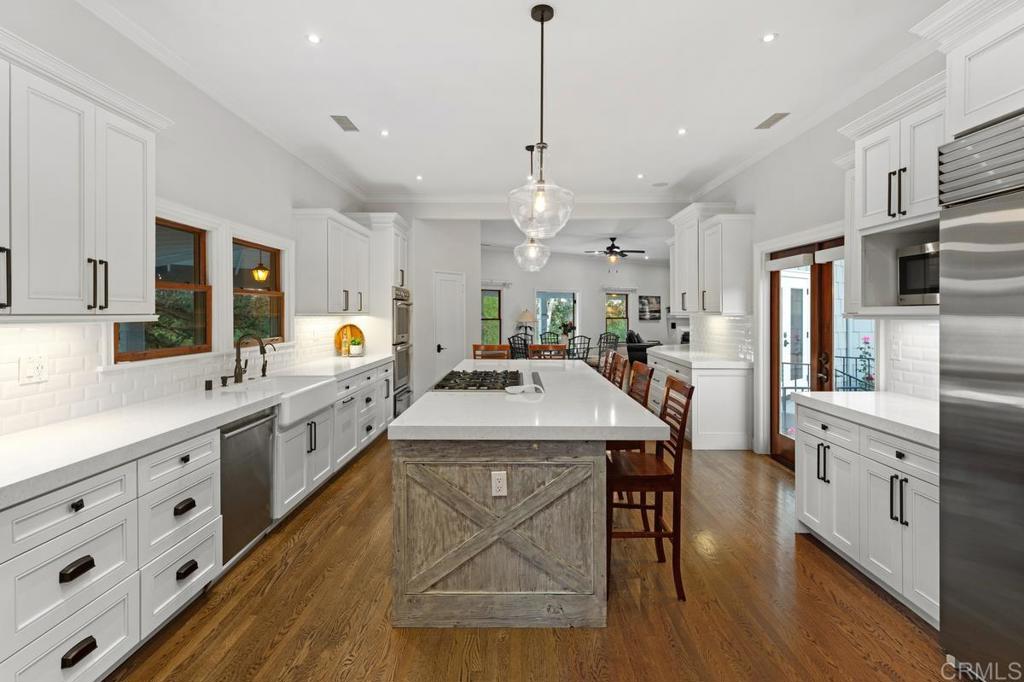 a large kitchen with kitchen island a island a sink a stove and a wooden floor