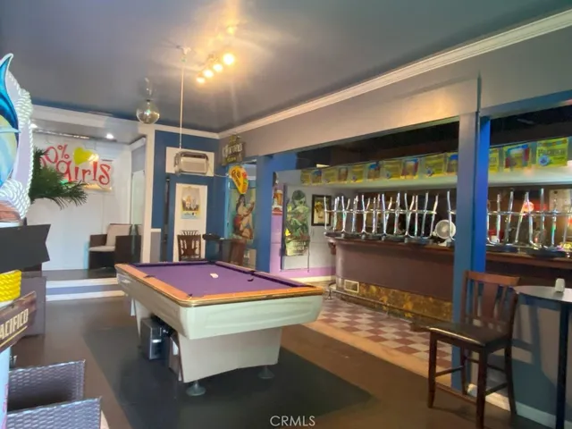 a living room with furniture pool table flat screen tv and windows