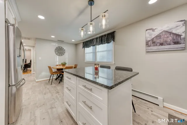 a open kitchen with stainless steel appliances granite countertop a sink a stove and a refrigerator