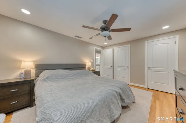 a spacious bedroom with a bed and a ceiling fan