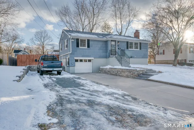 a front view of a house with a yard covered in snow