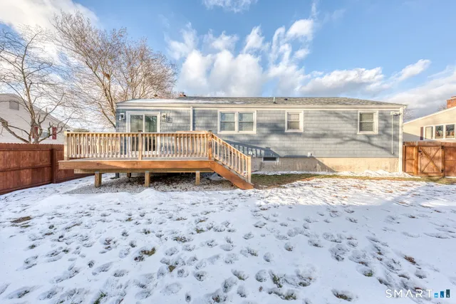 a view of a house with backyard and wooden fence