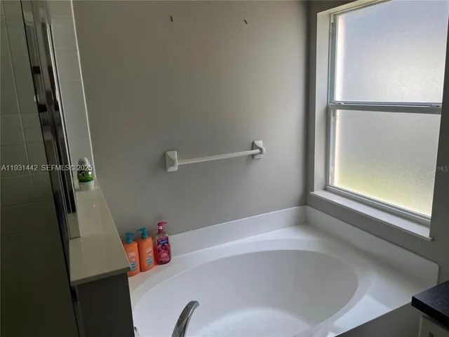 a white bath tub sitting next to a shower
