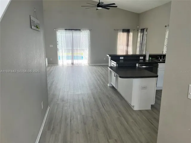 a kitchen with a sink and wooden floor