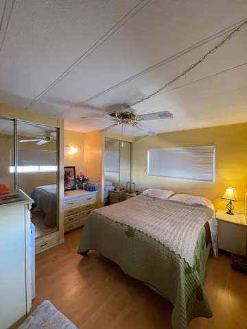 a spacious bedroom with a bed and a lamp