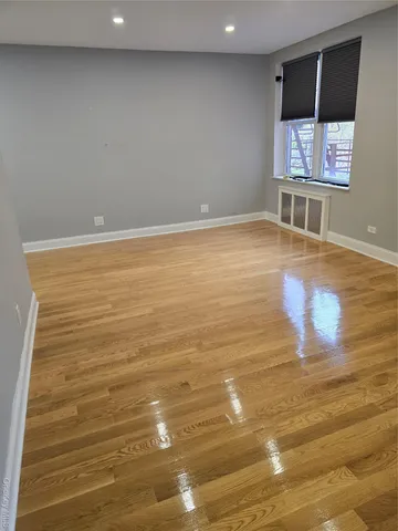 a view of a room with wooden floor and flat screen tv