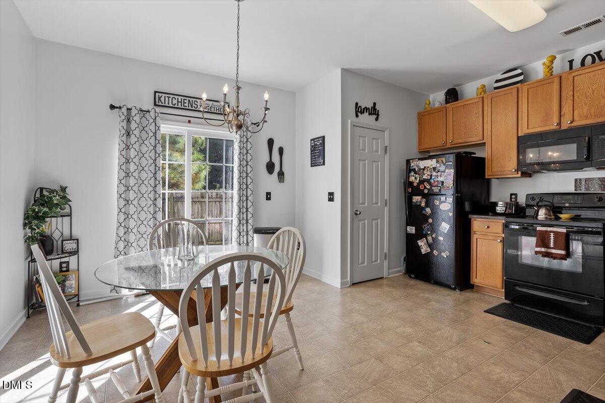 1409 Oxleymare Drive Raleigh, NC 27610 - Photo 12 of 28 a kitchen with stainless steel appliances a refrigerator a stove a dining table and chairs