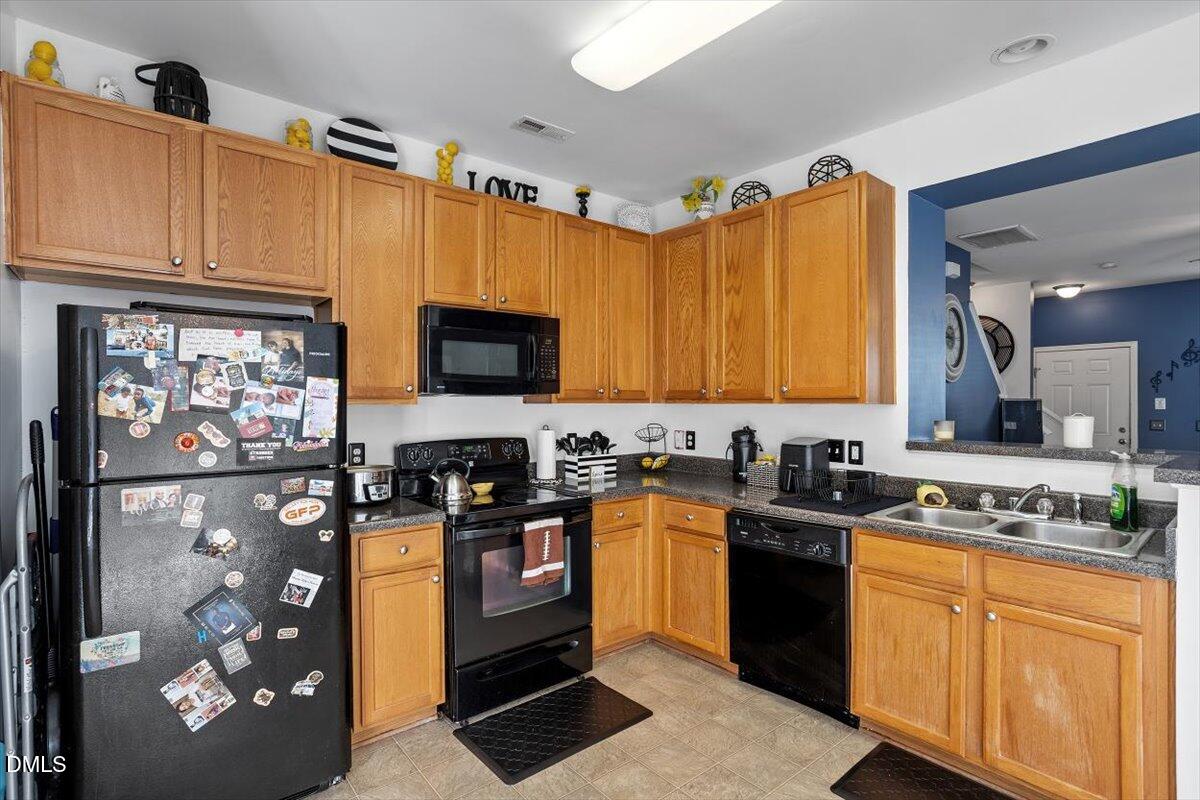 1409 Oxleymare Drive Raleigh, NC 27610 - Photo 15 of 28 a kitchen with stainless steel appliances granite countertop a stove a sink dishwasher and a microwave oven with cabinets