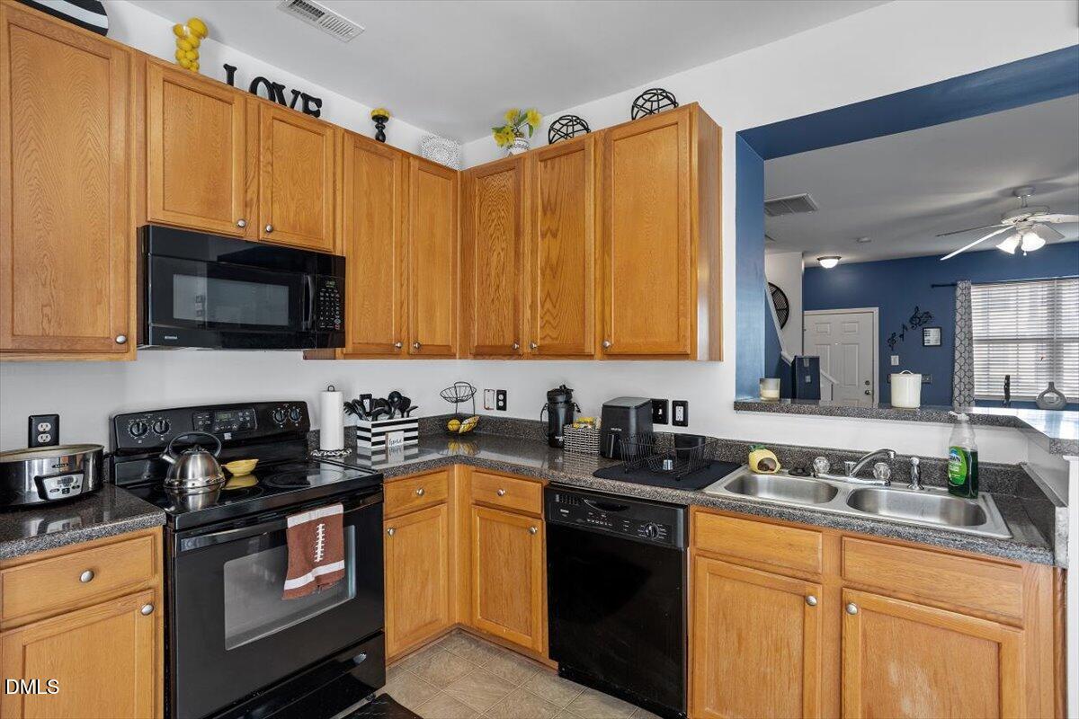 1409 Oxleymare Drive Raleigh, NC 27610 - Photo 16 of 28 a kitchen with granite countertop a sink a stove top oven a counter space and cabinets