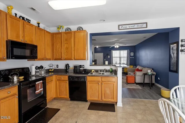 a kitchen with granite countertop a sink dishwasher stove top oven and cabinets
