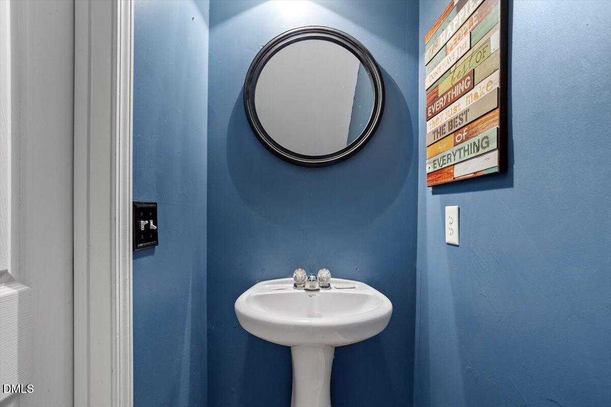 1409 Oxleymare Drive Raleigh, NC 27610 - Photo 20 of 28 a bathroom with a sink and a mirror