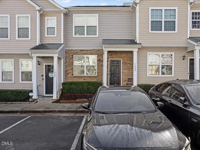 a view of a brick house with many windows and yard