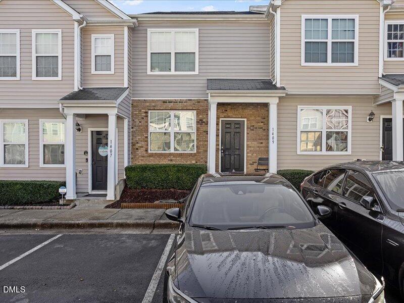 1409 Oxleymare Drive Raleigh, NC 27610 - Photo 2 of 28 a view of a brick house with many windows and yard