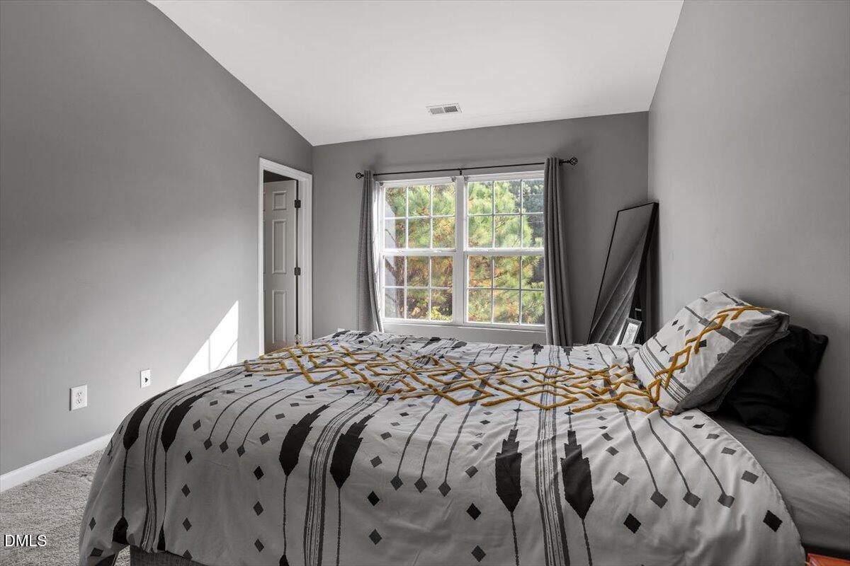 1409 Oxleymare Drive Raleigh, NC 27610 - Photo 21 of 28 a bed sitting in a bedroom next to a window