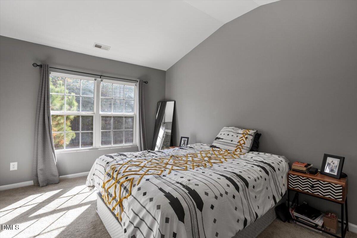 1409 Oxleymare Drive Raleigh, NC 27610 - Photo 22 of 28 a bedroom with a bed and a large window