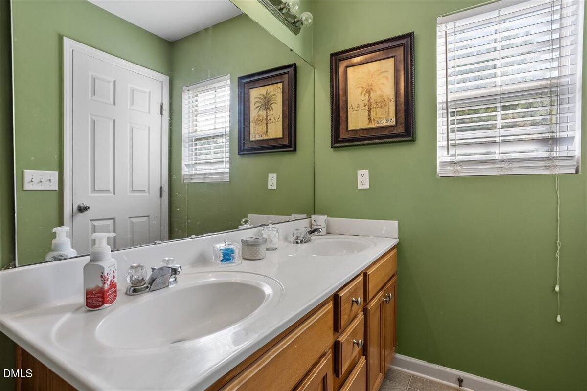 1409 Oxleymare Drive Raleigh, NC 27610 - Photo 25 of 28 a bathroom with a sink and a mirror