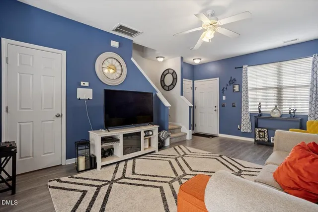 a living room with furniture a flat screen tv and a large window