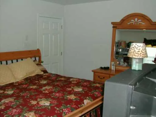a bed sitting in a bedroom next to a bathroom sink