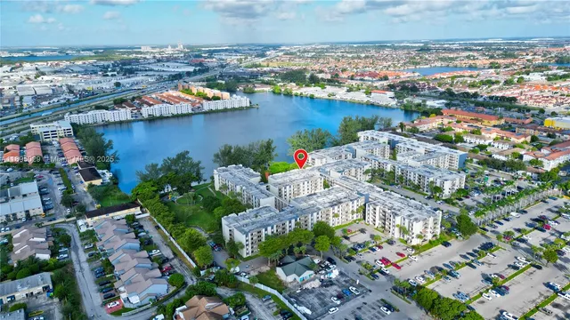 an aerial view of city and lake with boats and trees all around