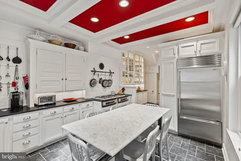 a kitchen with white cabinets and appliances