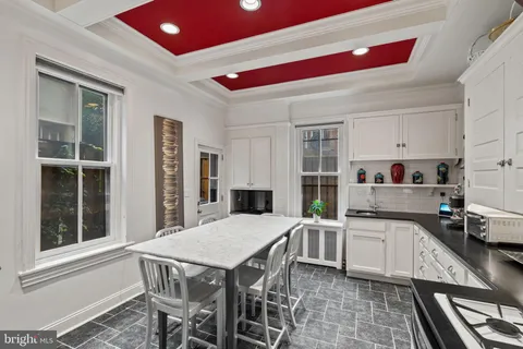 a kitchen with a table chairs sink and cabinets