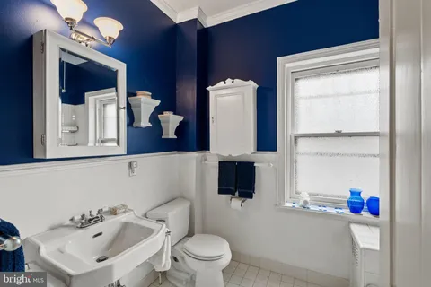 a bathroom with a sink a toilet and mirror