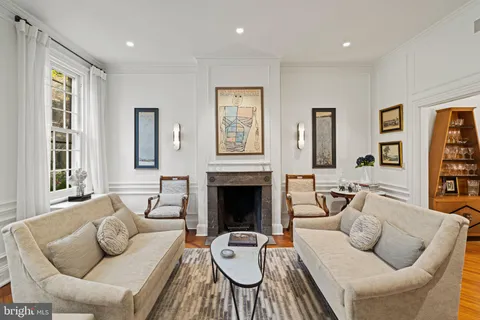a living room with furniture fireplace and a large window
