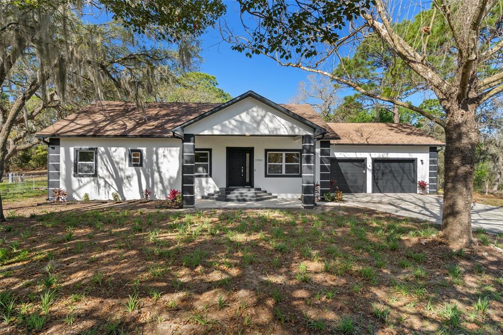17835 Alexson Street Spring Hill, FL 34610 - Photo 1 of 1 a front view of a house with a garden and yard