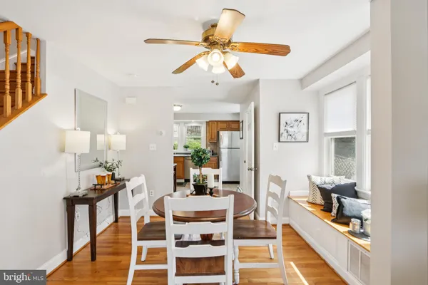 a kitchen with stainless steel appliances granite countertop a stove top oven a sink a dining table and chairs