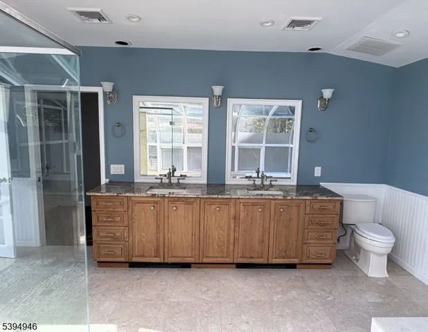 a bathroom with a granite countertop sink a toilet and shower