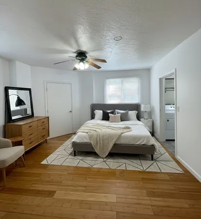 a bedroom with a large bed and a chandelier