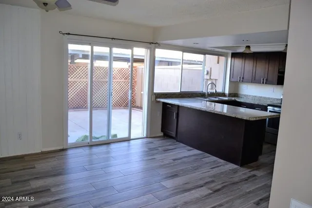 a kitchen with granite countertop a stove a sink and wooden floor