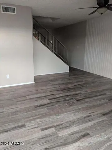 a view of a hallway with wooden floor and staircase