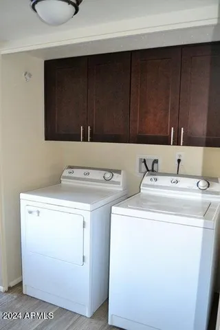 a view of an empty room with wooden floor and fan