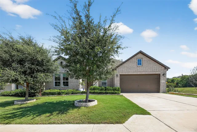a front view of a house with a yard and trees