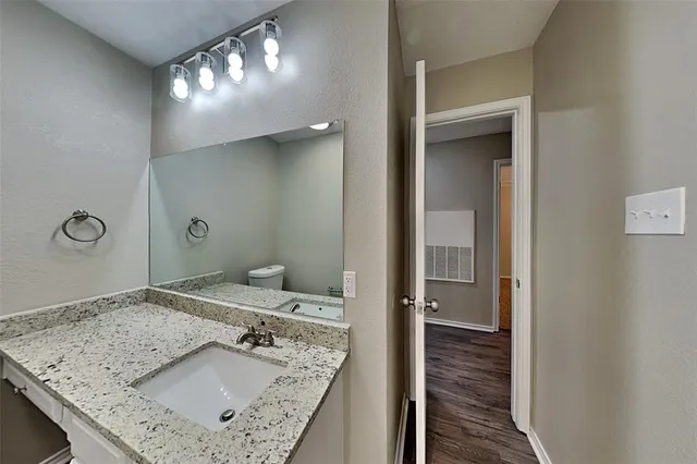 a bathroom with a granite countertop sink a mirror and shower