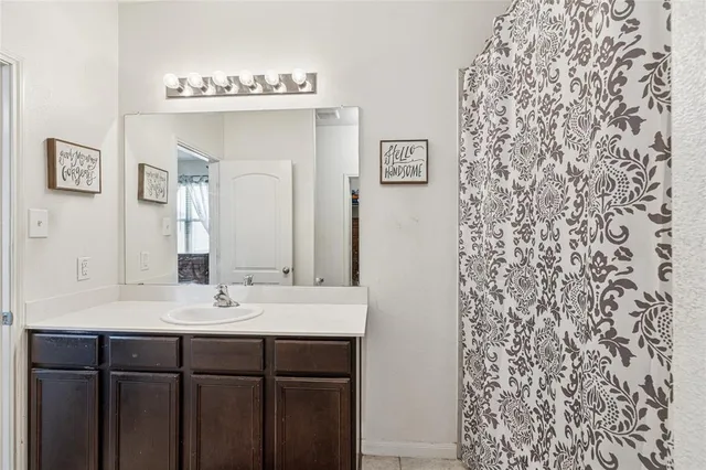 a bathroom with a sink a mirror and a shower