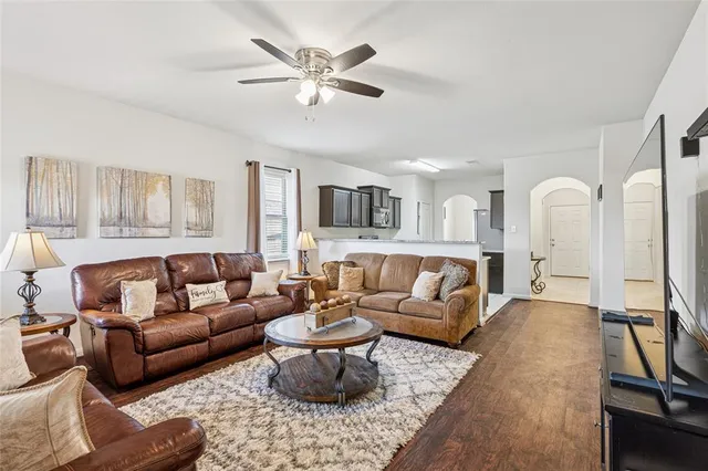 a living room with furniture a ceiling fan and a rug