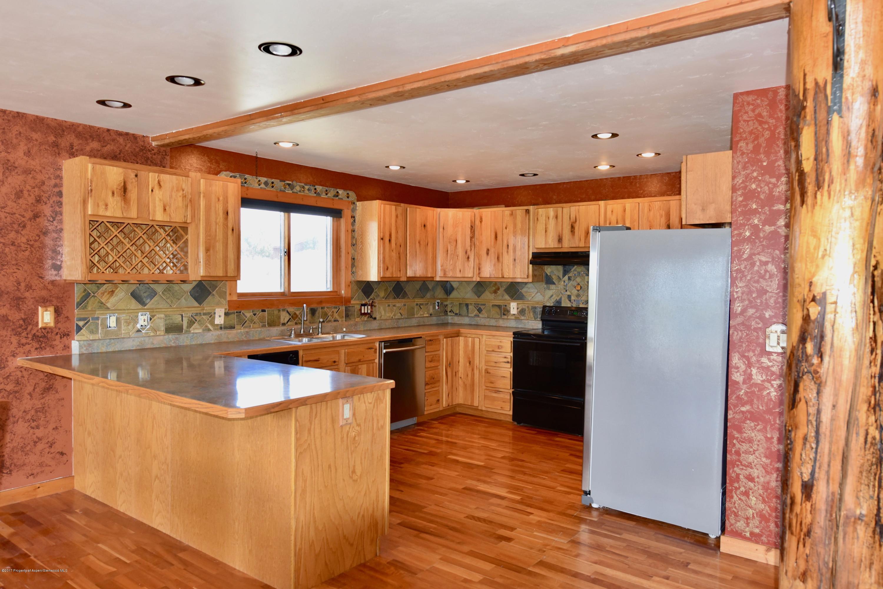 3744 County Road 237 Rifle, CO 81650 - Photo 28 of 37 a kitchen with granite countertop a refrigerator a sink a stove and cabinets