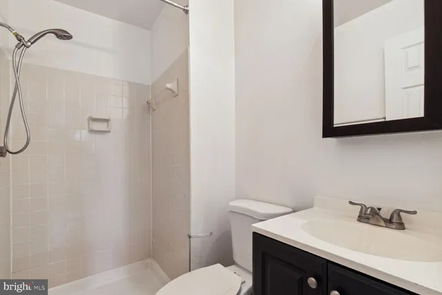 a bathroom with a sink vanity mirror and toilet
