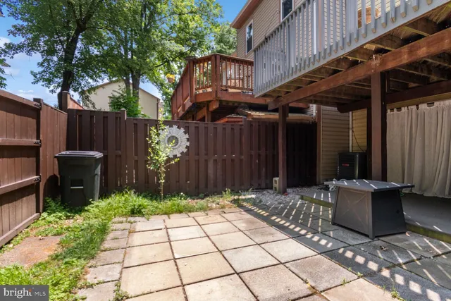 a wooden bench sitting in backside of a house with a garden