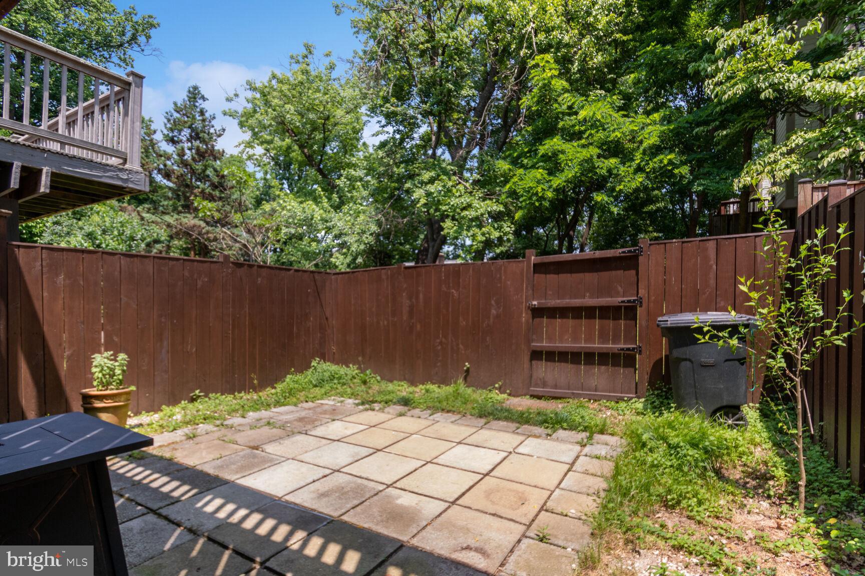 2849 Schoolhouse Circle Silver Spring, MD 20902 - Photo 27 of 31 a wooden bench sitting in backside of a house with a garden