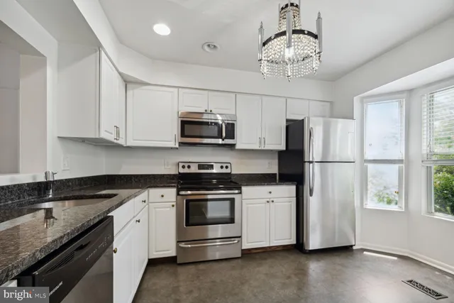 a kitchen with stainless steel appliances granite countertop a refrigerator a stove a sink dishwasher a microwave oven with cabinets and wooden floor