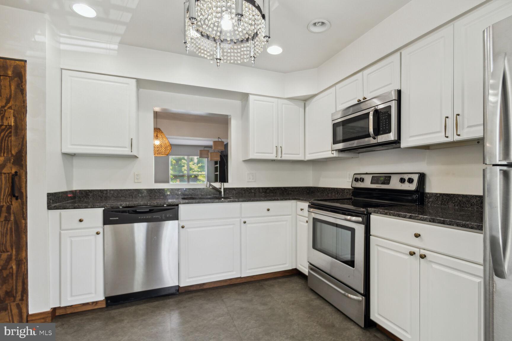 2849 Schoolhouse Circle Silver Spring, MD 20902 - Photo 4 of 31 a kitchen with stainless steel appliances granite countertop white cabinets a sink and dishwasher