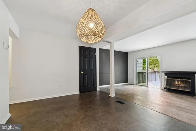 an empty room with windows and fireplace