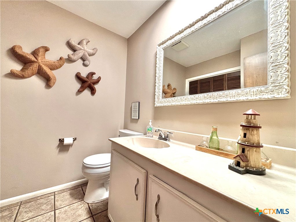 454 15th Street Port O'Connor, TX 77982 - Photo 13 of 45 a bathroom with a sink a toilet and a mirror