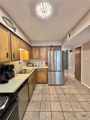 a kitchen with a sink a refrigerator and cabinets