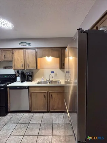 a kitchen with granite countertop a refrigerator and a sink