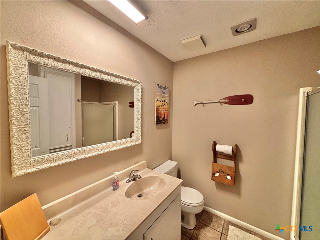 454 15th Street Port O'Connor, TX 77982 - Photo 27 of 45 a bathroom with a granite countertop sink toilet and mirror